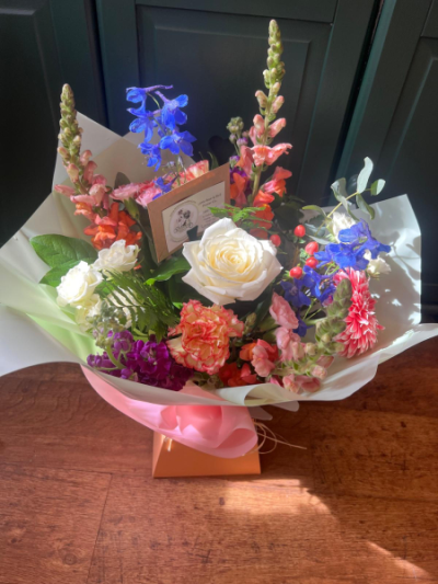 Celebration Bouquet - A vibrant hand-tied bouquet featuring bright seasonal flowers in cheerful mixed colours, carefully arranged to mark any special occasion. Flowers are dependent on seasonal availability.