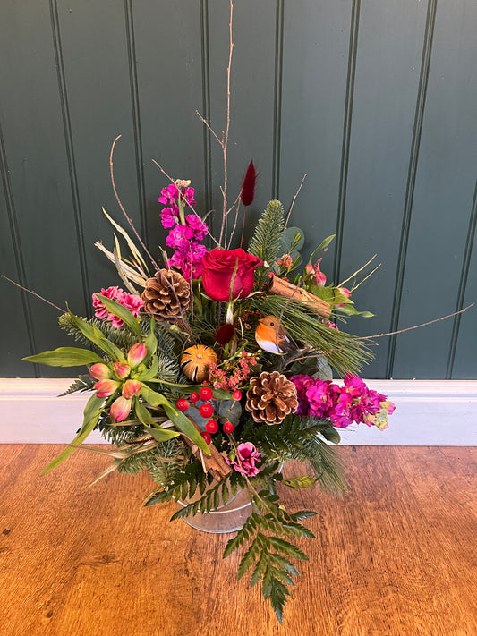 Christmas arrangement filled with seasonal flowers and Christmas foliage